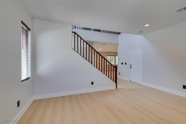 interior space featuring visible vents, baseboards, stairway, recessed lighting, and light wood finished floors