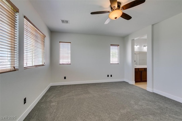 unfurnished room featuring baseboards, a ceiling fan, light colored carpet, and visible vents
