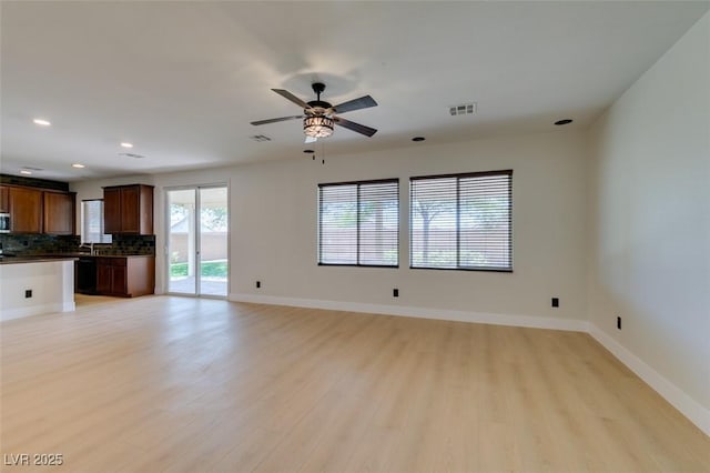 unfurnished living room featuring a ceiling fan, visible vents, baseboards, light wood finished floors, and recessed lighting