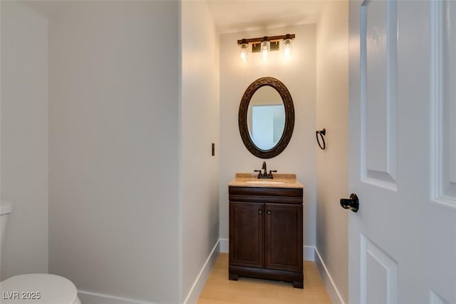 bathroom featuring vanity, baseboards, and toilet