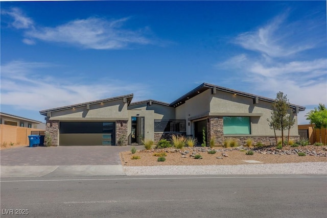 8310 W Camero Ave, Las Vegas, NV 89113 - view of front of home with a garage, stucco siding, decorative driveway, and stone siding