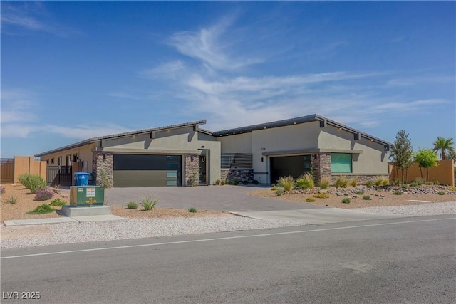 8310 W Camero Ave, Las Vegas, NV 89113 - view of front of home with a garage, stucco siding, stone siding, and fence