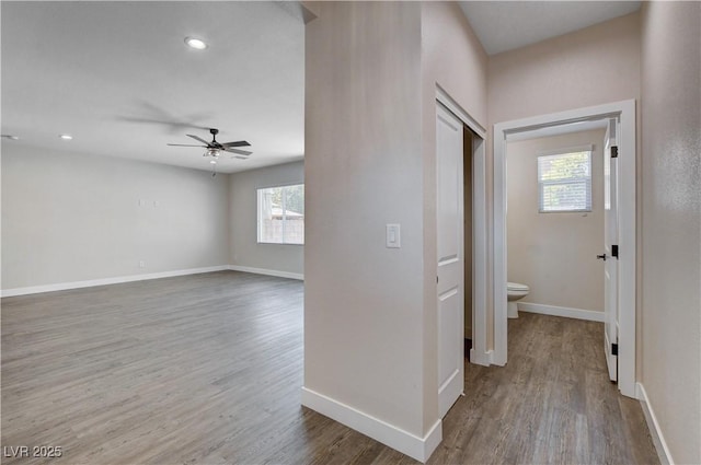 corridor featuring baseboards and wood finished floors