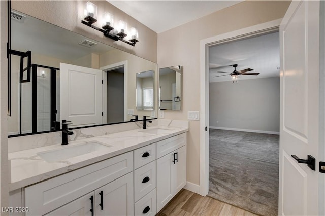 bathroom with a sink, a ceiling fan, wood finished floors, and visible vents