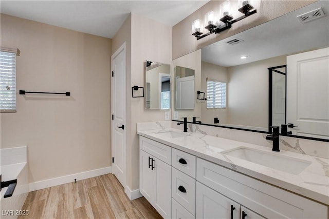 full bath with visible vents, a sink, and wood finished floors