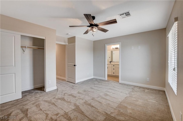unfurnished bedroom featuring visible vents, baseboards, a closet, and light colored carpet