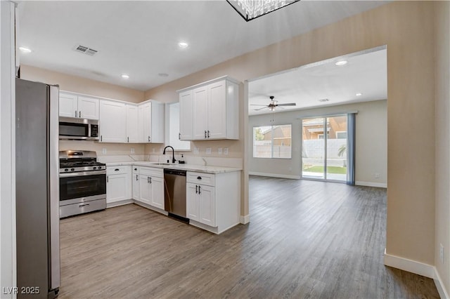 kitchen featuring visible vents, light wood-type flooring, baseboards, and stainless steel appliances