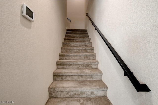 stairs featuring a textured wall