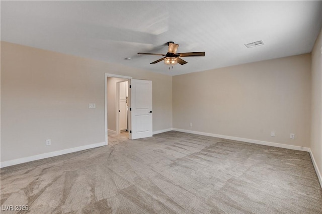 carpeted spare room with baseboards, a ceiling fan, and visible vents