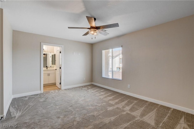 unfurnished bedroom with baseboards, a ceiling fan, connected bathroom, and light colored carpet