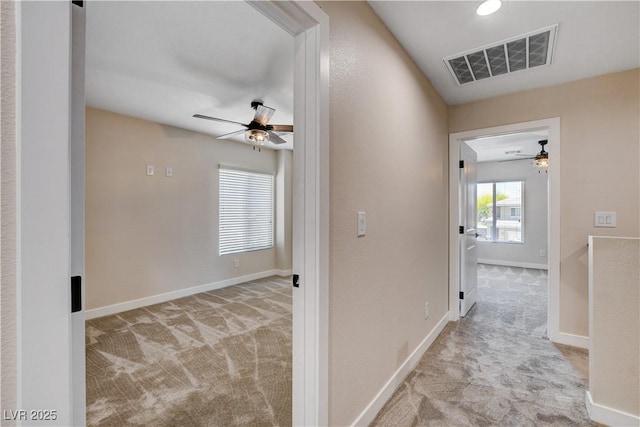 corridor with visible vents, carpet, and baseboards