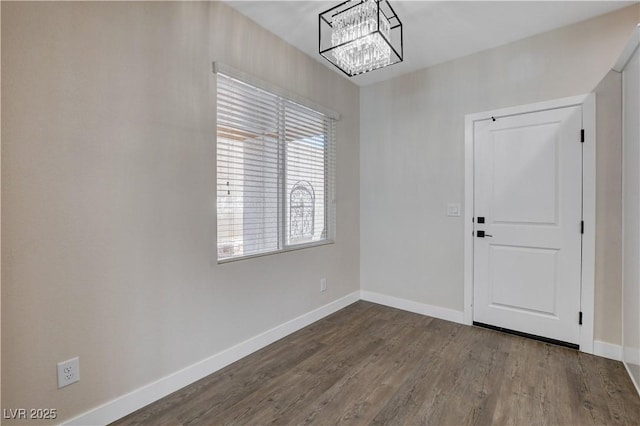 interior space featuring an inviting chandelier, baseboards, and dark wood-type flooring