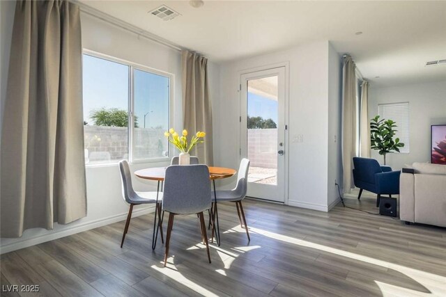 dining area with baseboards, wood finished floors, and visible vents