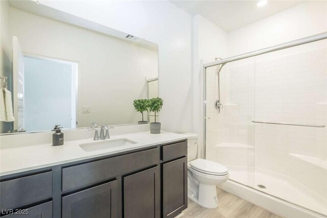 bathroom featuring vanity, a stall shower, toilet, and visible vents