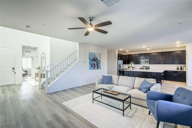 living area with visible vents, stairs, light wood-style floors, ceiling fan, and recessed lighting
