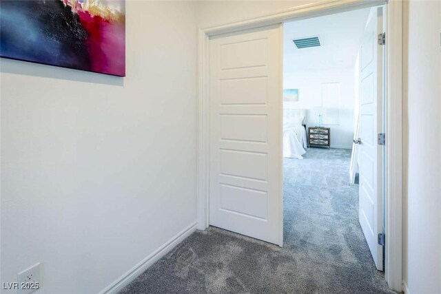 corridor featuring baseboards, carpet flooring, and visible vents