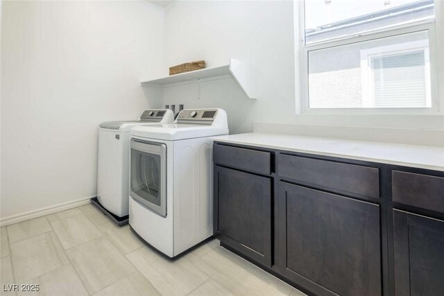 laundry area featuring baseboards, cabinet space, and washing machine and dryer