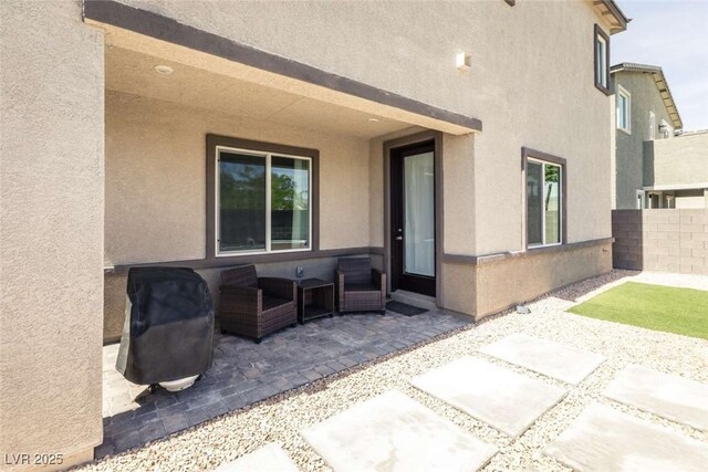 view of patio with outdoor lounge area, fence, and grilling area