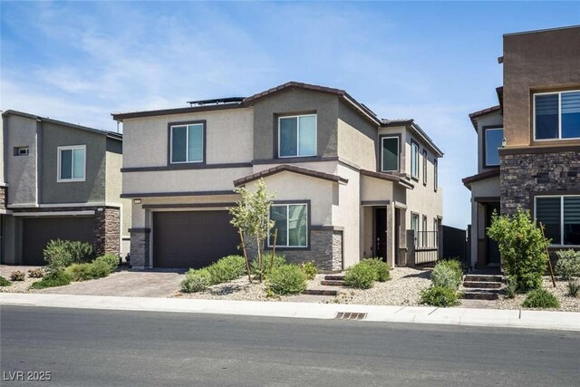 view of front of house featuring an attached garage, stucco siding, driveway, and stone siding