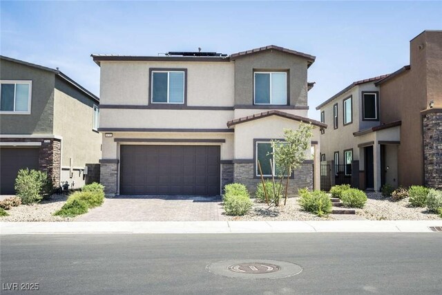 traditional-style home featuring stone siding, a garage, stucco siding, solar panels, and driveway