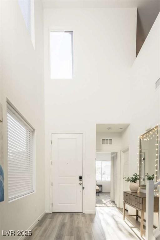 9732 Abel Cliff St, Las Vegas, NV 89143 - entryway with a towering ceiling, light wood-type flooring, and baseboards