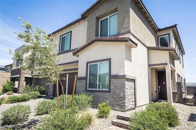 9732 Abel Cliff St, Las Vegas, NV 89143 - view of front of property featuring stone siding, stucco siding, and an attached garage