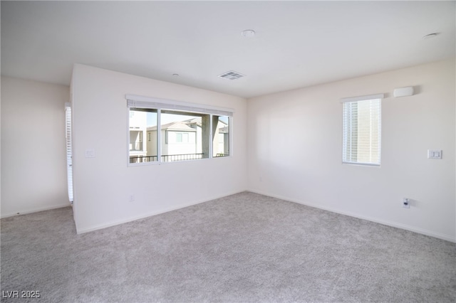 empty room with baseboards, carpet flooring, and visible vents