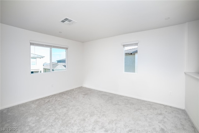 spare room with baseboards, carpet, and visible vents