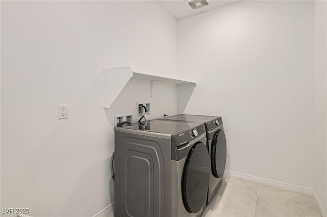 58 Sun Lily Ln, Henderson, NV 89011 - washroom featuring washing machine and clothes dryer, laundry area, light tile patterned flooring, and baseboards