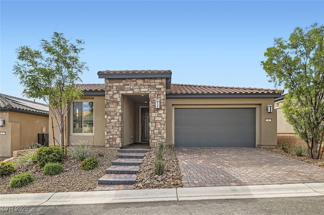58 Sun Lily Ln, Henderson, NV 89011 - view of front of property with decorative driveway, an attached garage, stucco siding, a tile roof, and central AC unit