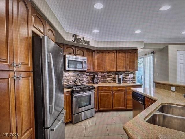 390 Rushing Creek Ct, Henderson, NV 89014 - kitchen with stainless steel appliances, a sink, tasteful backsplash, brown cabinetry, and recessed lighting