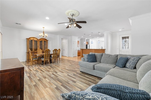 2164 Sawtooth Mountain Dr, Henderson, NV 89044 - living area featuring visible vents, ceiling fan with notable chandelier, ornamental molding, recessed lighting, and light wood-style flooring