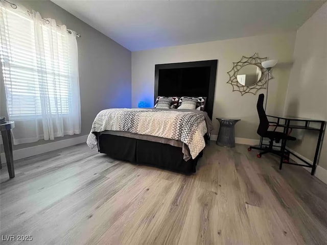 bedroom featuring light wood-style floors and baseboards