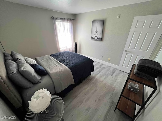 bedroom featuring baseboards and light wood finished floors