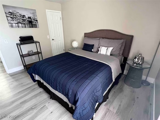 bedroom with baseboards and wood finished floors
