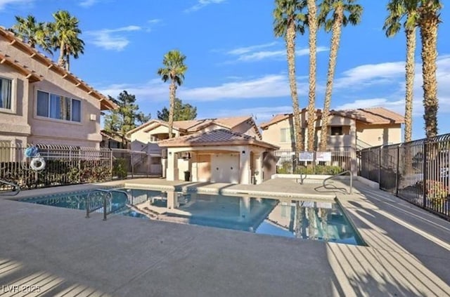 view of swimming pool with a fenced in pool, a patio area, fence, and a residential view