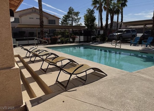 community pool featuring fence and a patio area