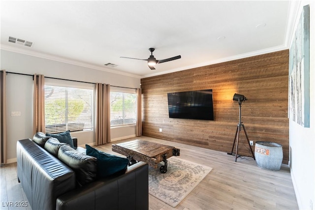 living area featuring visible vents, ornamental molding, and wooden walls