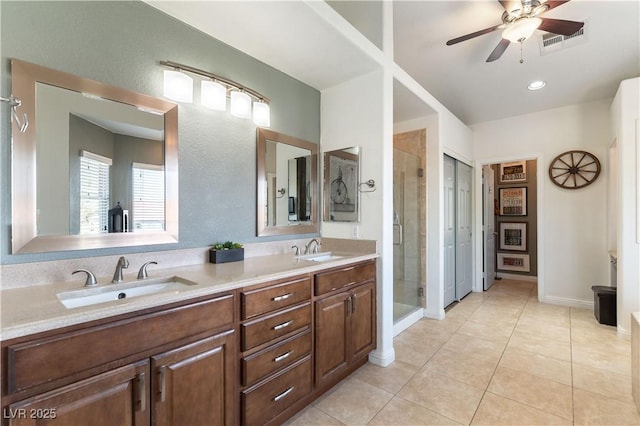 full bath with a sink, a shower stall, double vanity, and visible vents