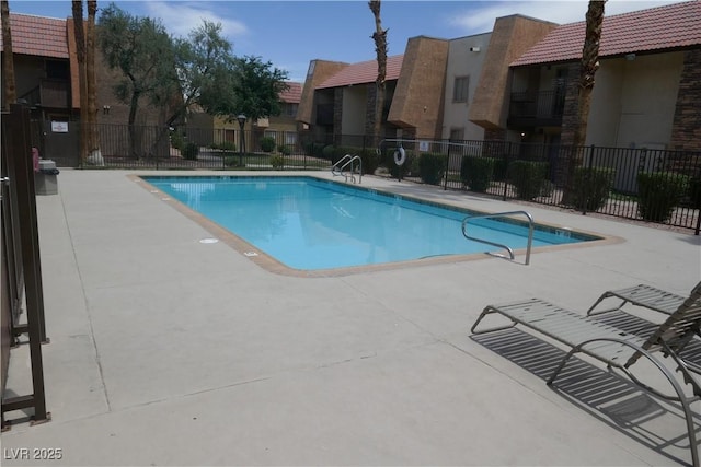 pool featuring a patio, fence, and a residential view