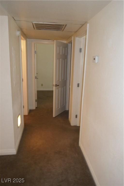 corridor featuring visible vents, carpet, and baseboards