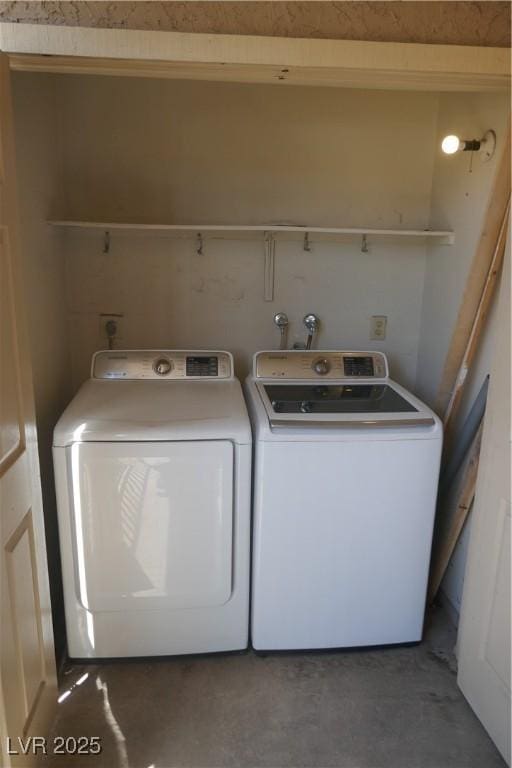 clothes washing area featuring separate washer and dryer and laundry area
