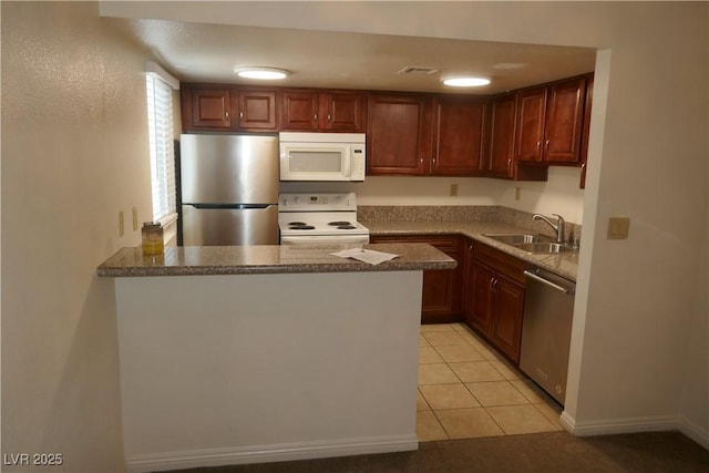kitchen featuring visible vents, a peninsula, light tile patterned flooring, a sink, and appliances with stainless steel finishes