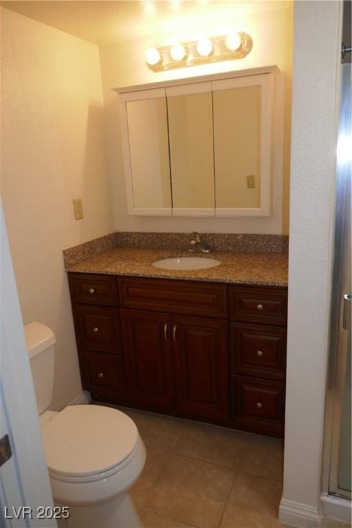 bathroom featuring vanity, tile patterned flooring, a stall shower, and toilet