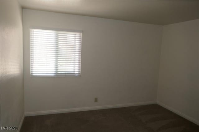 carpeted spare room featuring baseboards
