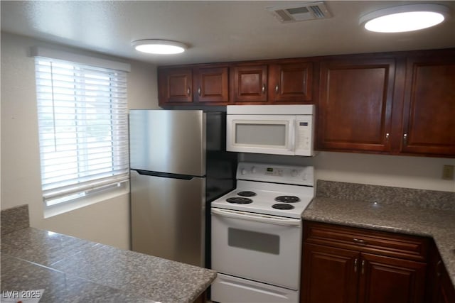 kitchen with tile countertops, white appliances, and visible vents