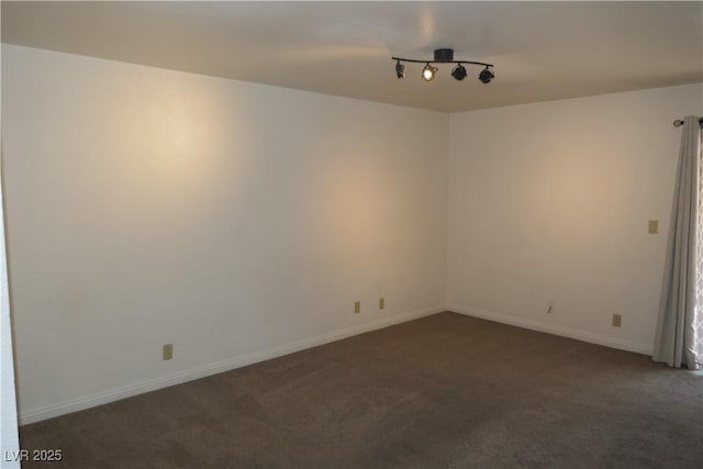carpeted empty room featuring baseboards