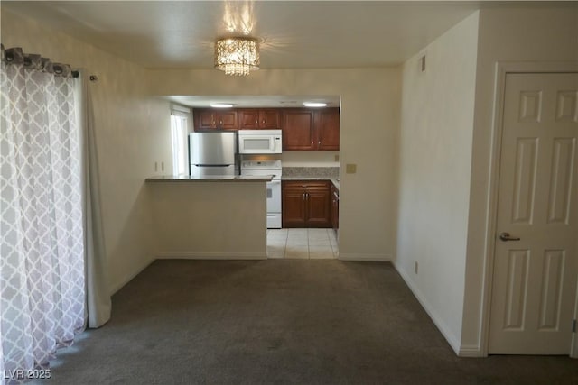 kitchen featuring baseboards, visible vents, white appliances, and light colored carpet