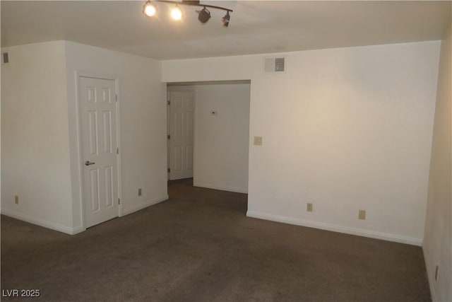 empty room featuring carpet flooring, baseboards, and visible vents