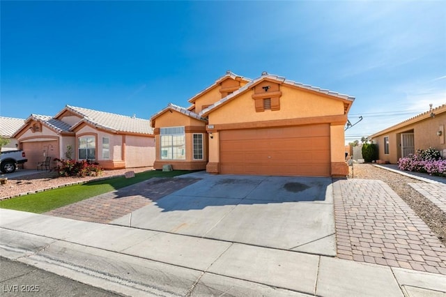 view of front of property featuring an attached garage, stucco siding, and concrete driveway